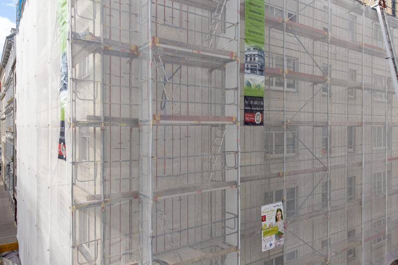 Das Gebäudeeck mit Gerüst eingekleidet ist hinter den weißen Schutznetzen des Gerüsts zu erkennen. Das Gebäudeeck mit Gerüst eingekleidet ist hinter den weißen Schutznetzen des Gerüsts zu erkennen.