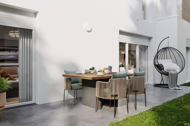 Terrasse eines der Häuser. Ein gedeckter Tisch mit vier Stühlen ist dort. Auf der Seite befindet sich ein Hängender Sessel in einem Merallgestell. Terrasse eines der Häuser. Ein gedeckter Tisch mit vier Stühlen ist dort. Auf der Seite befindet sich ein Hängender Sessel in einem Merallgestell.