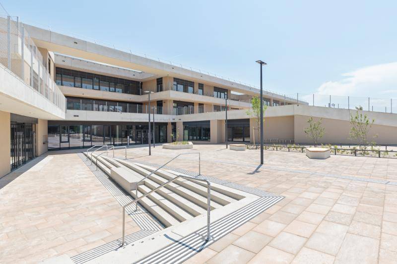 Durch das leicht, vom Gebäude weg, steigende Areal, sind hier Treppen nach unten ins Erdgeschoss. Das ganze Gebäude ist in hellen Farben, hauptsächlich Beige, zu sehen. Der Freibereich ist mit hellen, großen Natursteinen belegt. Durch das leicht, vom Gebäude weg, steigende Areal, sind hier Treppen nach unten ins Erdgeschoss. Das ganze Gebäude ist in hellen Farben, hauptsächlich Beige, zu sehen. Der Freibereich ist mit hellen, großen Natursteinen belegt.