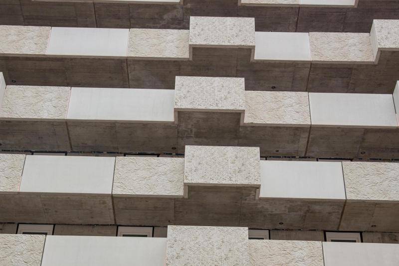 Hier sind Balkongeländer zu sehen, die sich an einem der Gebäude befinden. Die Geländer sind massiv aus Beton Elementen in grau und teilweise beige gefertigt. Hier sind Balkongeländer zu sehen, die sich an einem der Gebäude befinden. Die Geländer sind massiv aus Beton Elementen in grau und teilweise beige gefertigt.