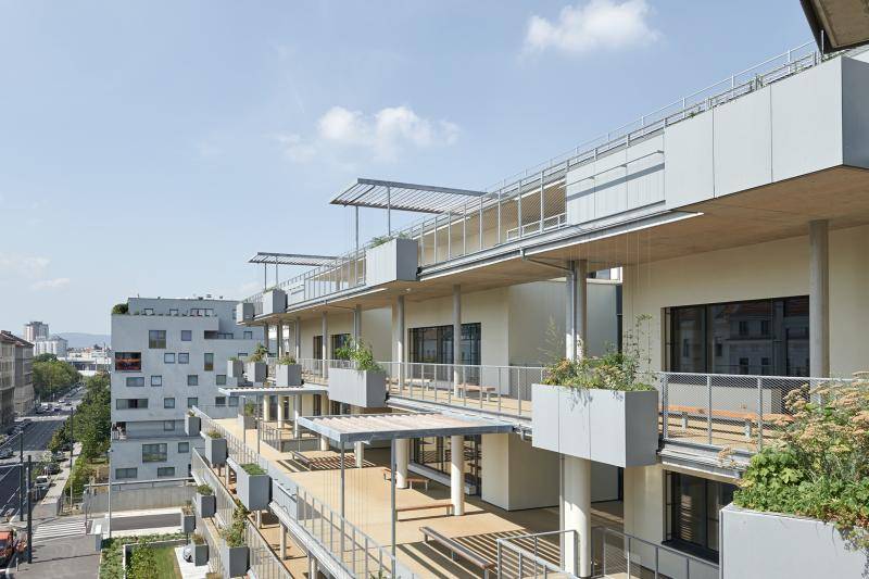 Aufnahme aus dem 4.OG. Die Balkone/Terrassen sind mit einem hellen, sandfarbenen Belag und grauen Metall Geländern. An den Geländern hängen große Kästen mit Pflanzen und Blumen. Aufnahme aus dem 4.OG. Die Balkone/Terrassen sind mit einem hellen, sandfarbenen Belag und grauen Metall Geländern. An den Geländern hängen große Kästen mit Pflanzen und Blumen.