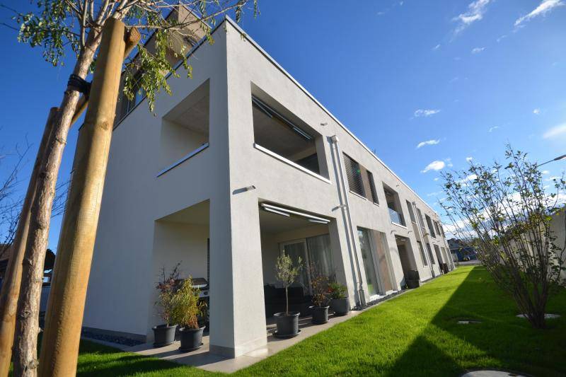 Loggien und Terrassen sind übereinander, jeweils an der Ecke des Hauses, angeordnet.. Das Gebäude ist von grünem Rasen umgeben. Loggien und Terrassen sind übereinander, jeweils an der Ecke des Hauses, angeordnet.. Das Gebäude ist von grünem Rasen umgeben.