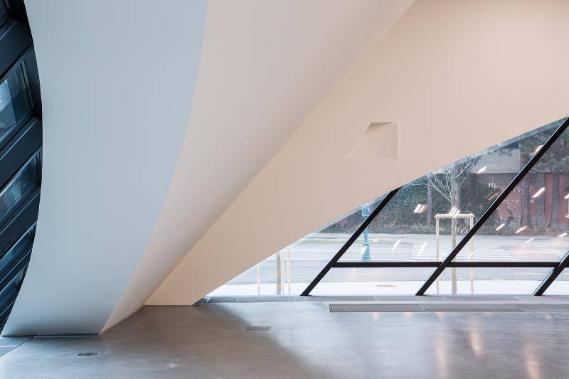 Zu sehen ist eine Innenaufnahme einer der Gebäudeecken. Das massive Gebäudeeck steigt langsam schräg geneigt nach oben an. Rechts und links davon sind Fensterflächen zu sehen. Zu sehen ist eine Innenaufnahme einer der Gebäudeecken. Das massive Gebäudeeck steigt langsam schräg geneigt nach oben an. Rechts und links davon sind Fensterflächen zu sehen.