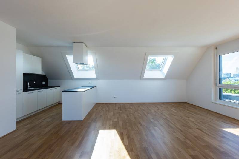 Eine Dachgeschosswohnung mit offener Küche. Natürliche Belichtung durch Dachflächenfenster. Parkettboden. Küche sowie Wandoberflächen in weiß. Eine Dachgeschosswohnung mit offener Küche. Natürliche Belichtung durch Dachflächenfenster. Parkettboden. Küche sowie Wandoberflächen in weiß.