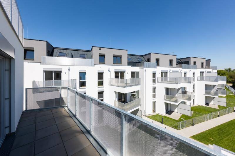 Blick von einem oberen Balkon auf den daneben liegenden Bau. Um die Gebäude sind grünflächen, sowie ein Weg. Blick von einem oberen Balkon auf den daneben liegenden Bau. Um die Gebäude sind grünflächen, sowie ein Weg.