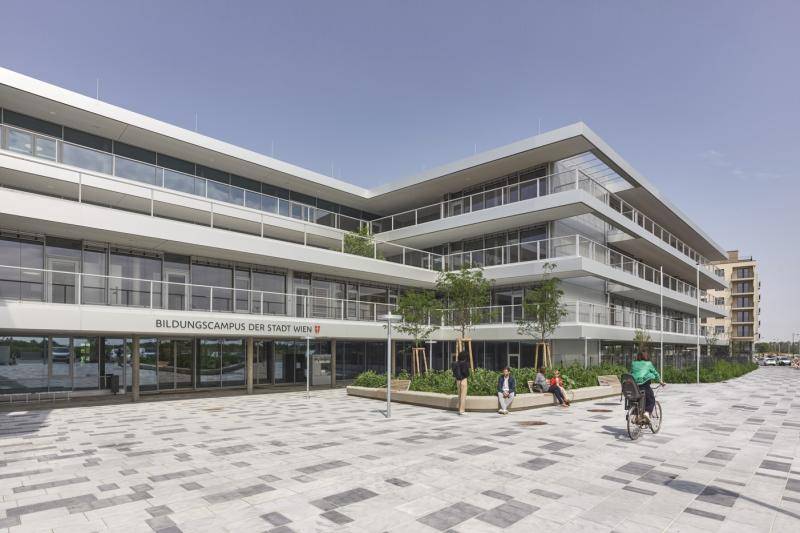 Das Gebäude mit den Balkonen und Terrassen rundherum. Der Platz davor mit hellen Pflastersteinen. Das Gebäude mit den Balkonen und Terrassen rundherum. Der Platz davor mit hellen Pflastersteinen.