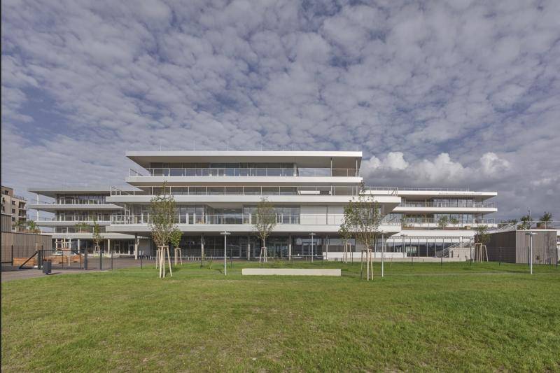 Ansicht des Gebäudes aus der Ferne. Im Vordergrund grüne Wiese und neu gesetzte Bäume. Ansicht des Gebäudes aus der Ferne. Im Vordergrund grüne Wiese und neu gesetzte Bäume.